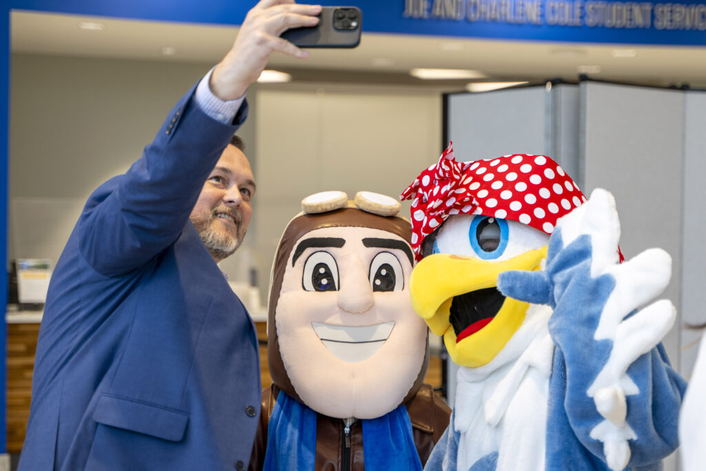President Hurst takes a selfie with Rosie the Eagle and Rowdy the Raider