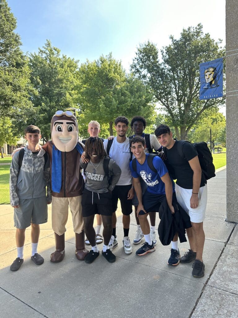 Rowdy the Raider poses with a group of RSC students on the campus mall